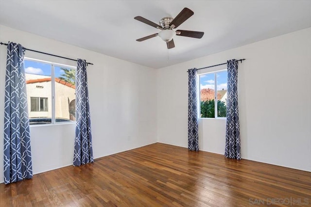 empty room with ceiling fan and dark wood-type flooring