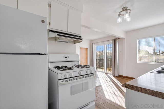 kitchen with white cabinetry, plenty of natural light, white appliances, and light hardwood / wood-style flooring