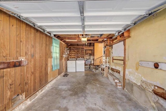 garage featuring wood walls, washer and clothes dryer, a garage door opener, and sink