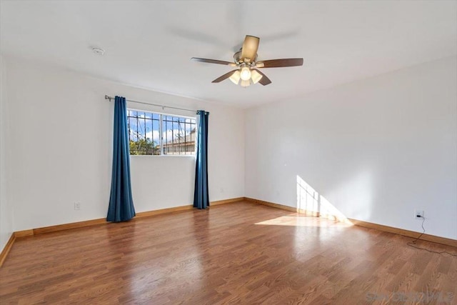 empty room with hardwood / wood-style flooring and ceiling fan