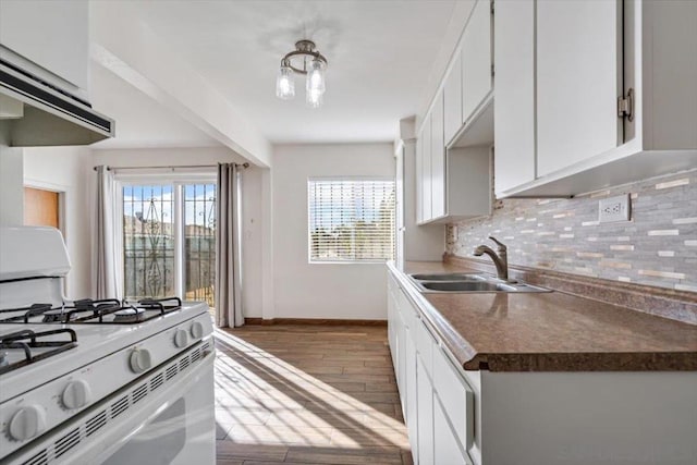 kitchen featuring light hardwood / wood-style floors, white cabinetry, gas range gas stove, and tasteful backsplash