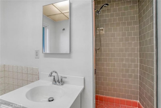 bathroom featuring a tile shower and sink