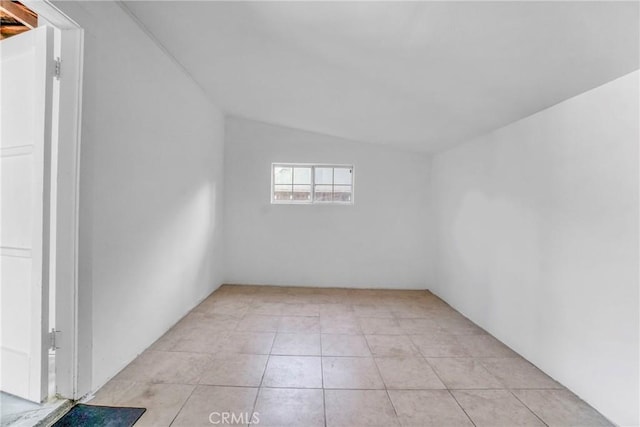 additional living space featuring light tile patterned floors and vaulted ceiling