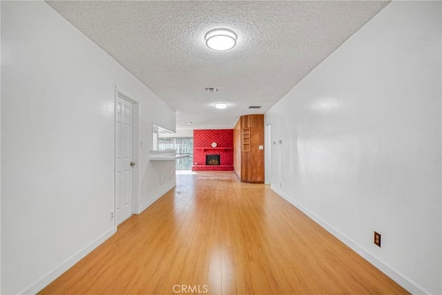 corridor with wood-type flooring and a textured ceiling