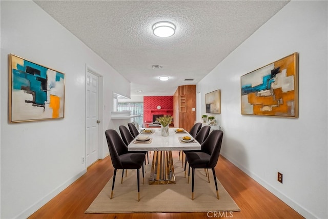 dining room featuring hardwood / wood-style flooring and a textured ceiling