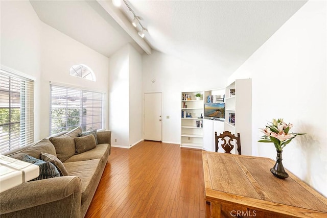 living room featuring light hardwood / wood-style flooring, high vaulted ceiling, and track lighting