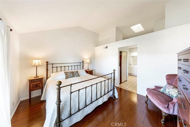 bedroom featuring lofted ceiling, wood-type flooring, and connected bathroom