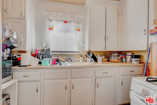 kitchen featuring white cabinets, white electric range oven, decorative backsplash, and sink