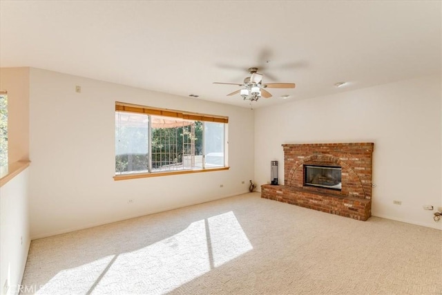 unfurnished living room featuring light carpet, a brick fireplace, and ceiling fan