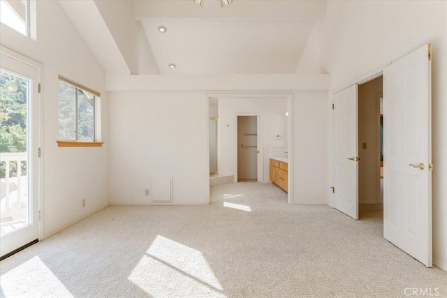 spare room featuring light carpet and vaulted ceiling