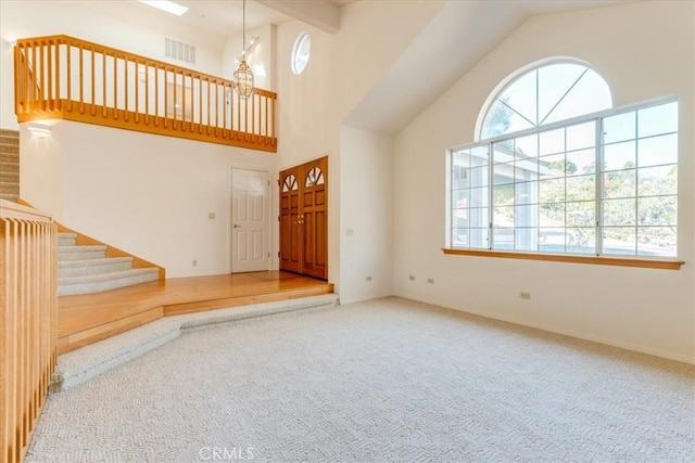 entryway featuring carpet floors and high vaulted ceiling