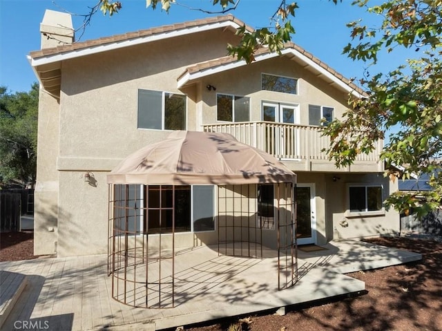 back of house with a balcony and a patio