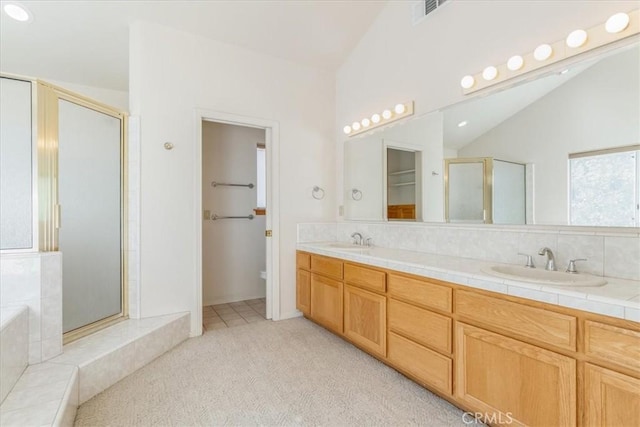 bathroom with vanity, separate shower and tub, and vaulted ceiling