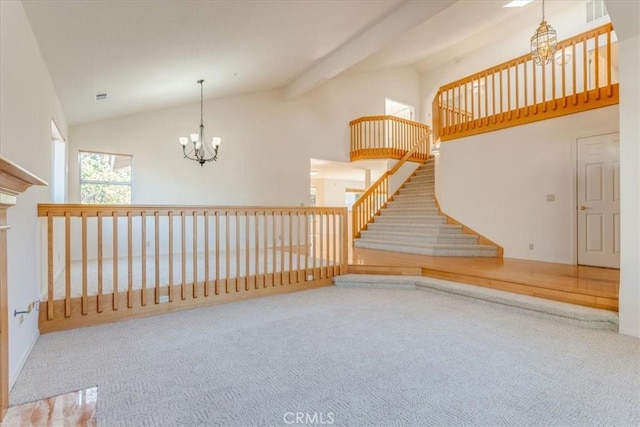 carpeted empty room with beam ceiling, high vaulted ceiling, and a chandelier