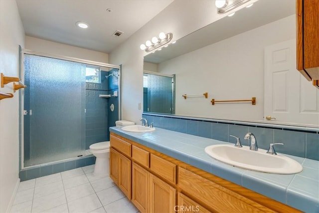 bathroom with decorative backsplash, walk in shower, vanity, tile patterned flooring, and toilet