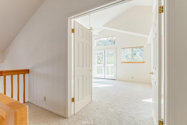 hallway with light colored carpet and vaulted ceiling