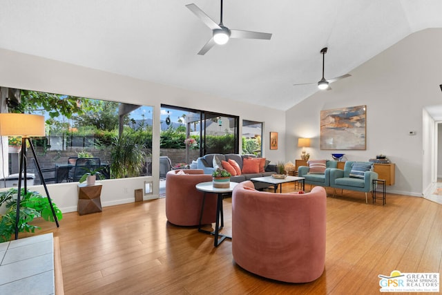 living room with ceiling fan, light hardwood / wood-style flooring, and vaulted ceiling