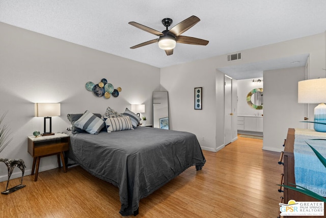 bedroom with ceiling fan, ensuite bath, and light hardwood / wood-style flooring