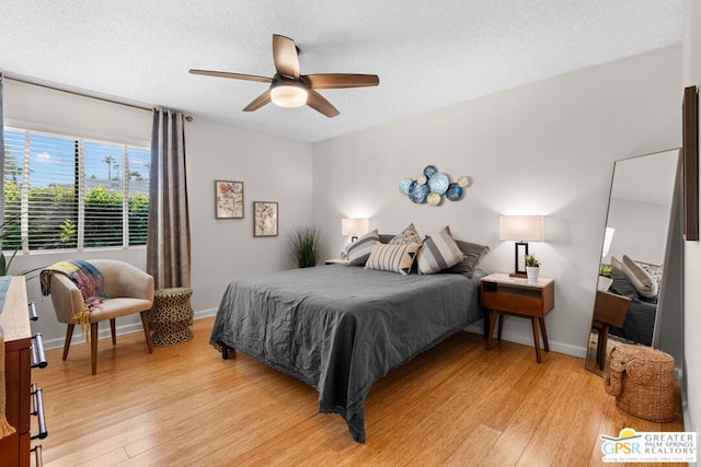 bedroom featuring ceiling fan, light hardwood / wood-style floors, and a textured ceiling