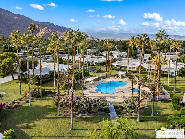 view of pool with a mountain view and a lawn