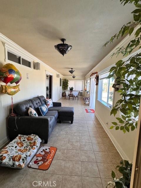 living room with ornamental molding and light tile patterned floors