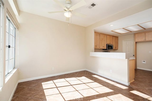 kitchen featuring kitchen peninsula, light brown cabinetry, tile counters, and ceiling fan