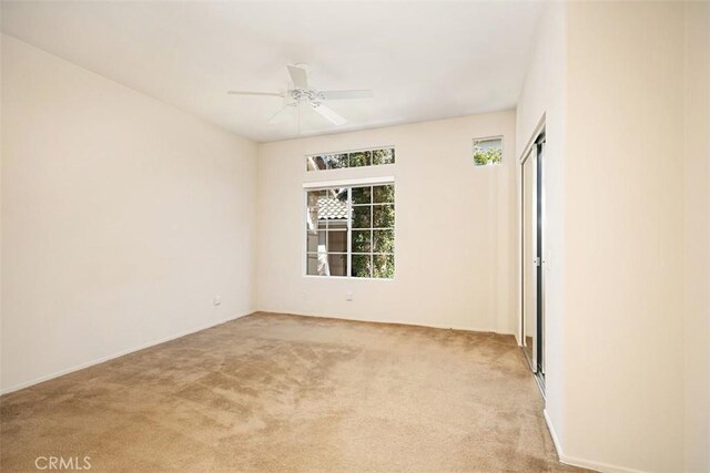 unfurnished room with ceiling fan and light colored carpet