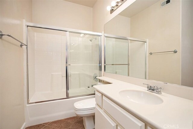 full bathroom with toilet, vanity, tile patterned floors, and enclosed tub / shower combo