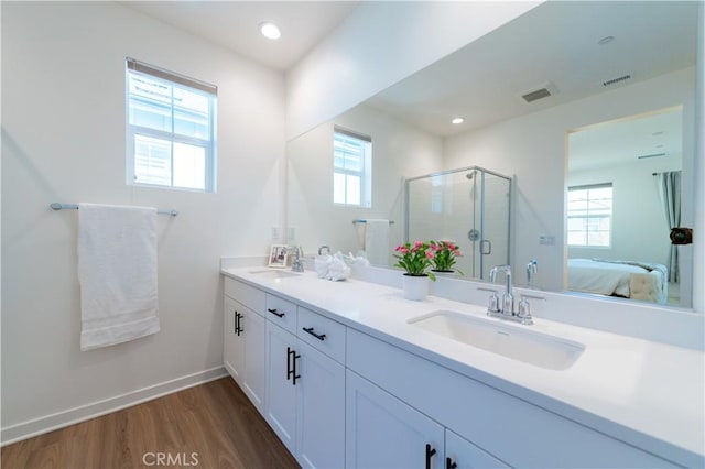 bathroom with vanity, a healthy amount of sunlight, a shower with shower door, and wood-type flooring