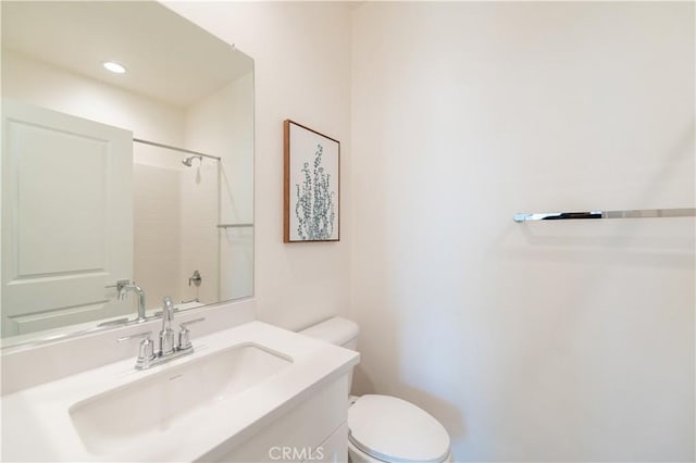 bathroom with a shower, vanity, and toilet