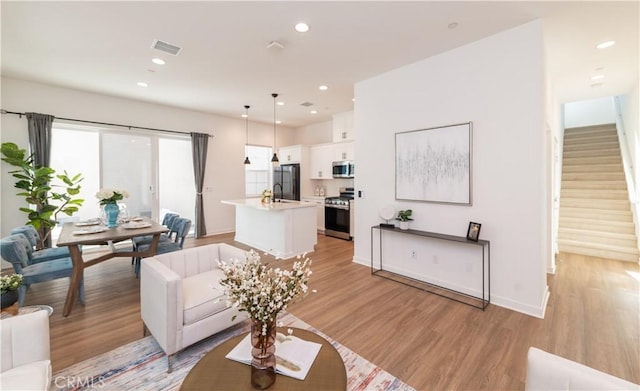 living room with sink and light hardwood / wood-style floors