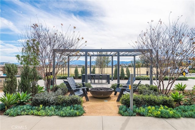 exterior space with a fire pit, a mountain view, and a pergola