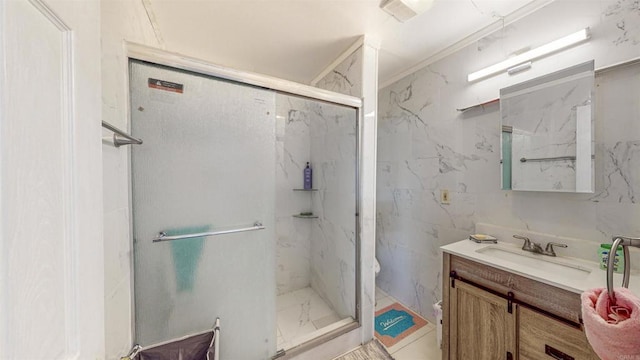 bathroom with tile walls, vanity, a shower with shower door, and ornamental molding