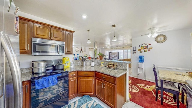 kitchen with light stone counters, hanging light fixtures, kitchen peninsula, ceiling fan, and stainless steel appliances