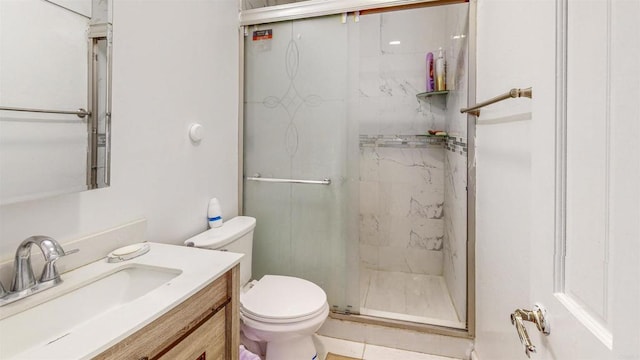 bathroom with vanity, tile patterned flooring, a shower with shower door, and toilet