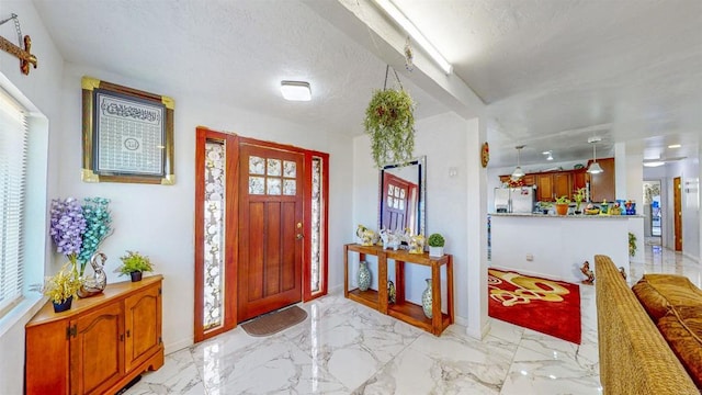 foyer entrance with plenty of natural light and a textured ceiling