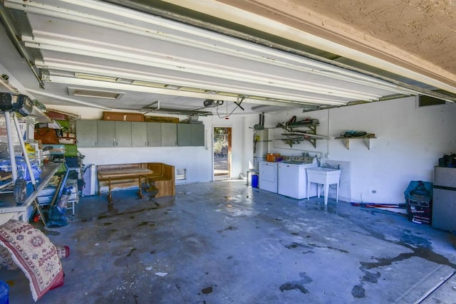 garage with independent washer and dryer and sink