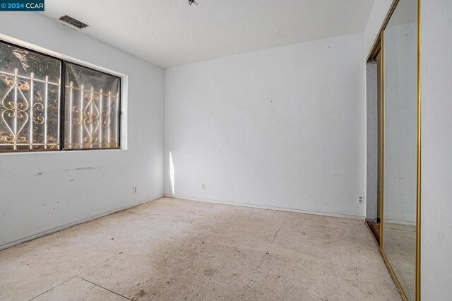 unfurnished bedroom featuring concrete floors and a closet