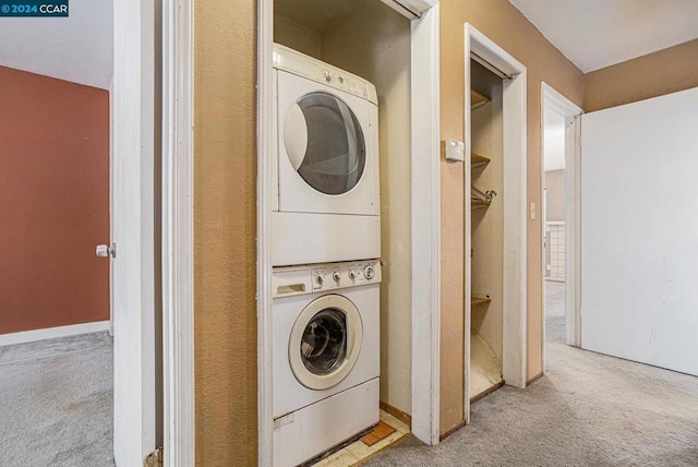 laundry room with light colored carpet and stacked washing maching and dryer