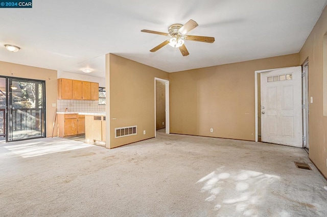 unfurnished living room featuring ceiling fan and light colored carpet