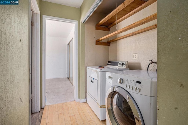 washroom featuring independent washer and dryer and light hardwood / wood-style flooring