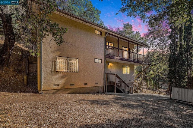 back house at dusk with a balcony