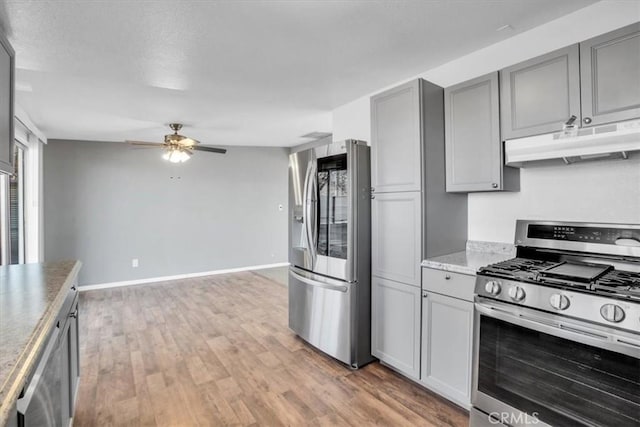 kitchen with ceiling fan, gray cabinets, appliances with stainless steel finishes, and light hardwood / wood-style flooring