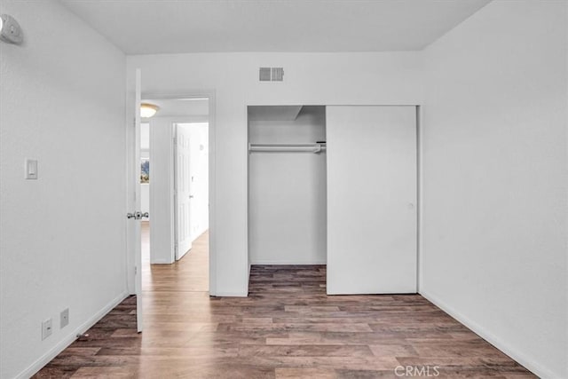 unfurnished bedroom featuring wood-type flooring and a closet