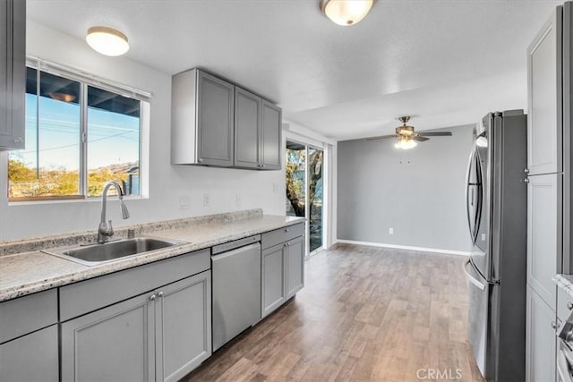 kitchen featuring plenty of natural light, ceiling fan, sink, and appliances with stainless steel finishes