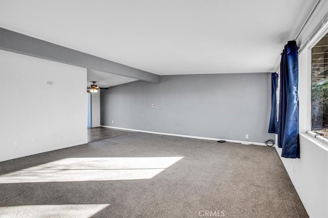 carpeted spare room featuring ceiling fan and beamed ceiling