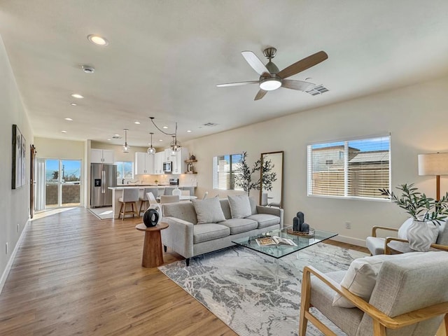 living room featuring ceiling fan and light hardwood / wood-style flooring