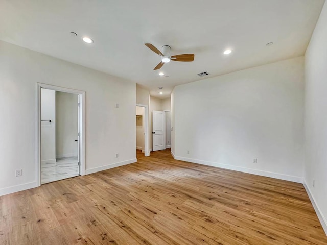 unfurnished bedroom featuring light hardwood / wood-style floors, ensuite bath, and ceiling fan