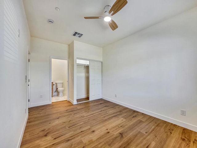 unfurnished bedroom featuring a closet, light hardwood / wood-style floors, ceiling fan, and connected bathroom