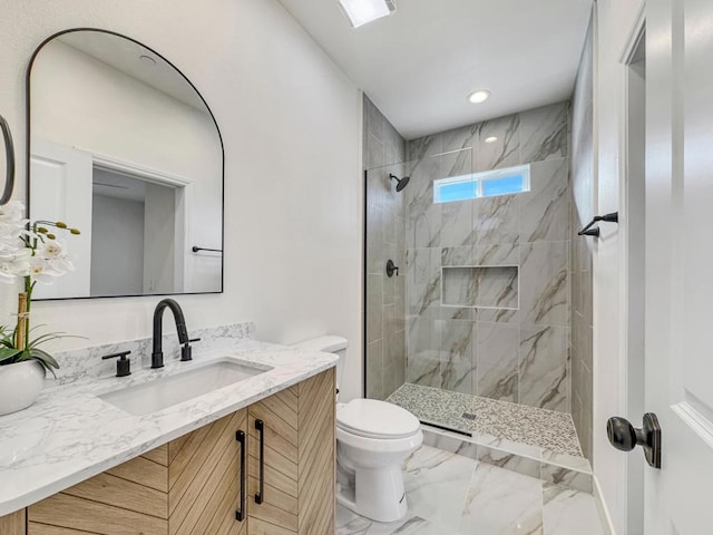 bathroom with vanity, toilet, and a tile shower